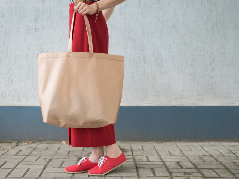 Žena nosi u ruci veliku torbu